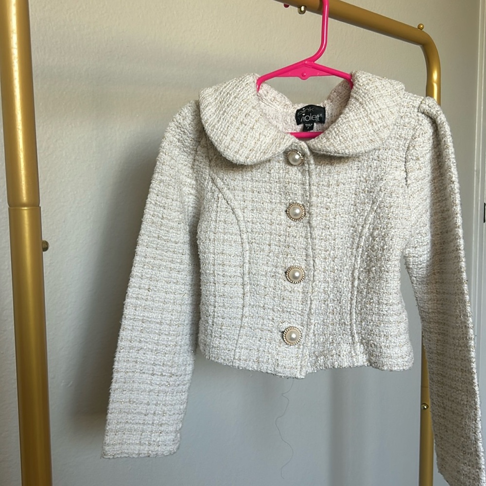 Formal cream coat with gold and pearl buttons.